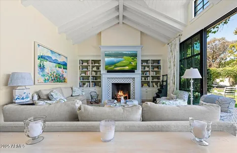 a living room with furniture a fireplace and a large window