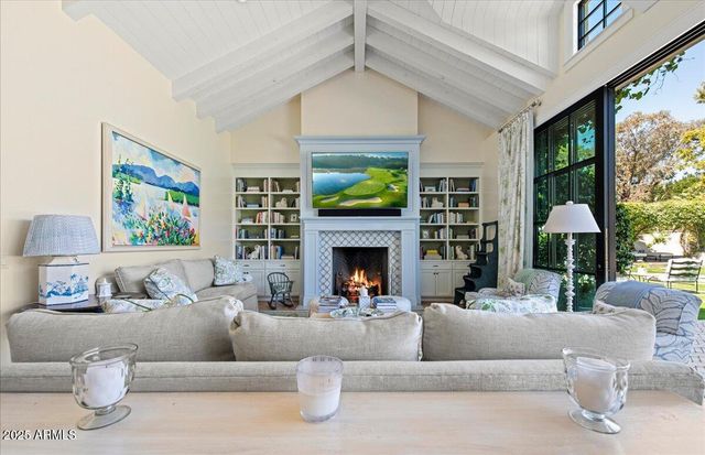 a living room with furniture a fireplace and a large window