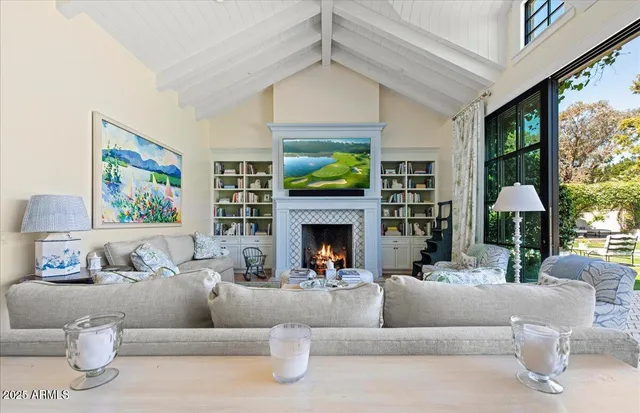 a living room with furniture a fireplace and a large window