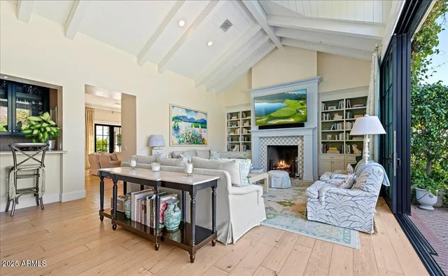 a living room with furniture a fireplace and a floor to ceiling window