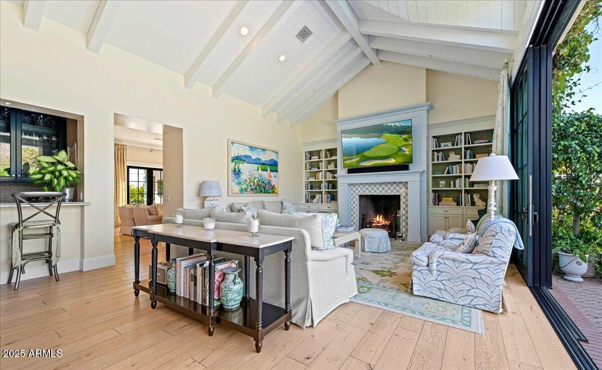 5446 East Exeter Boulevard Phoenix, AZ 85018 - Photo 13 of 59 a living room with furniture a fireplace and a floor to ceiling window