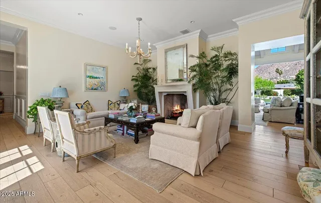 a living room with furniture a chandelier and a fireplace