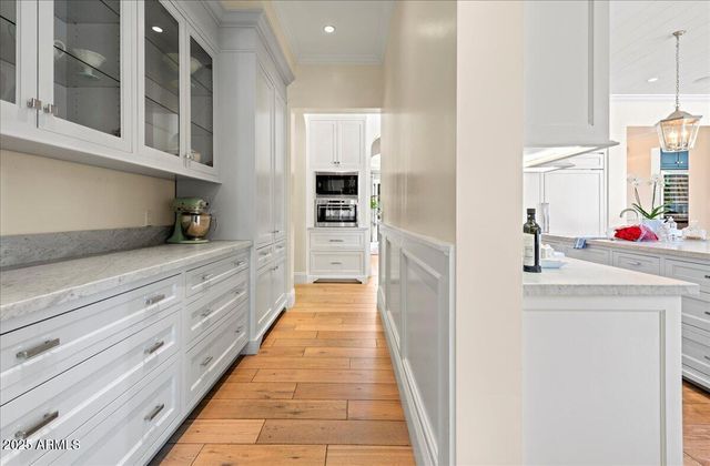 a bedroom with a bed painting on wall and windows