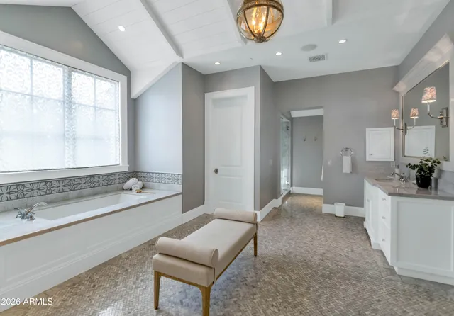 a view of a hallway with wooden floor and a bathroom