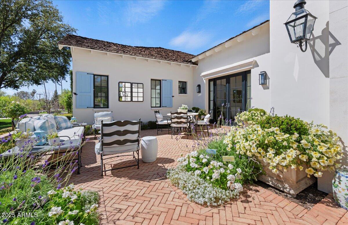 5446 East Exeter Boulevard Phoenix, AZ 85018 - Photo 3 of 59 a view of a patio with couches table and chairs potted plants and a large tree
