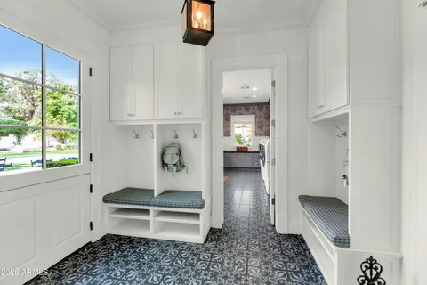 a living room with furniture large window and wooden floor