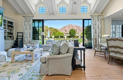 a living room with fireplace furniture and a large window