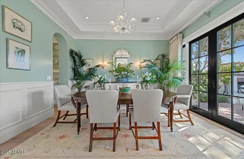 a view of a dining room with furniture a chandelier and wooden floor