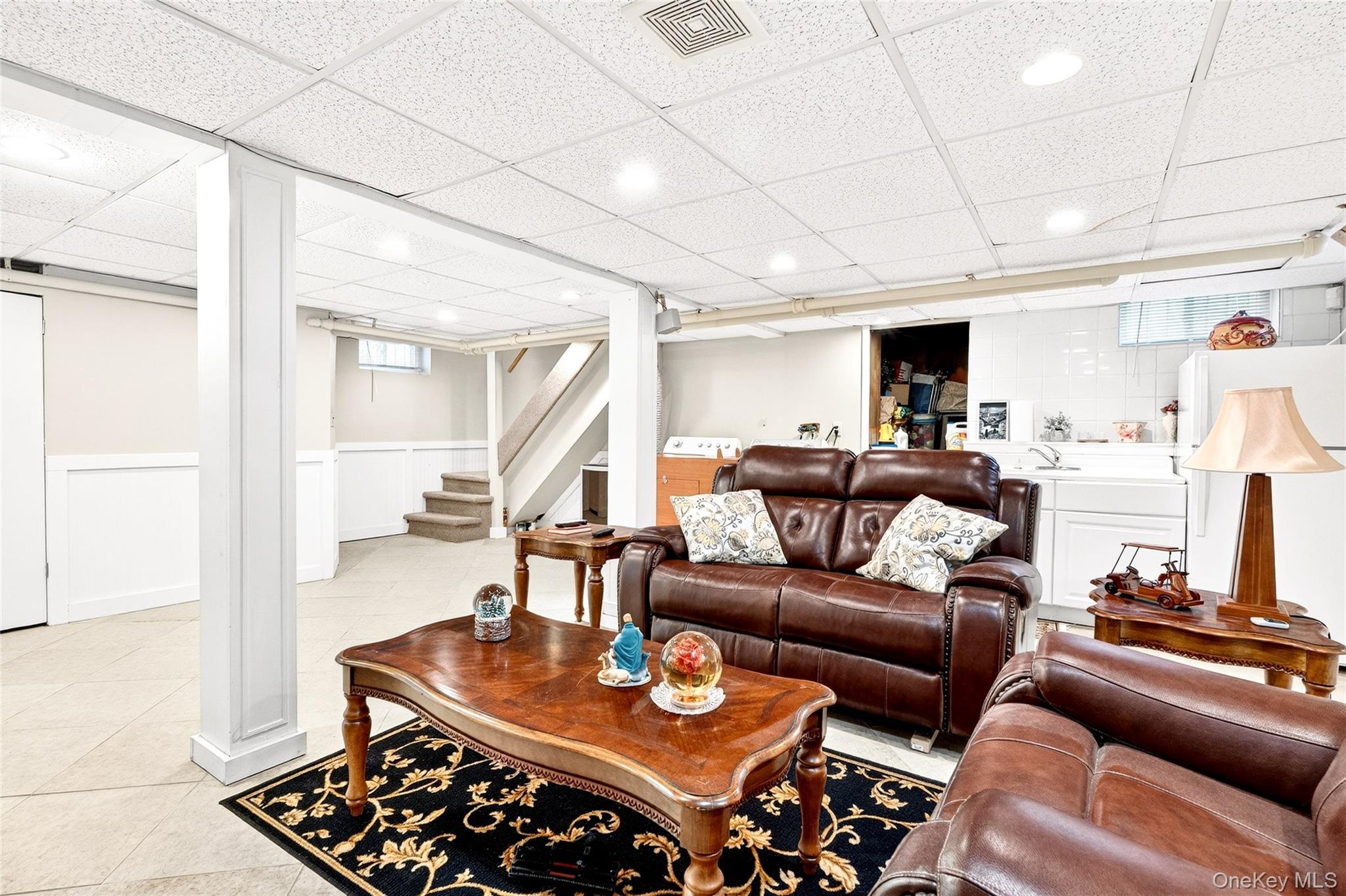 3334 Country Club Road Bronx, NY 10465 - Photo 42 of 49 Living area with a paneled ceiling, light tile patterned flooring, stairs, and wainscoting