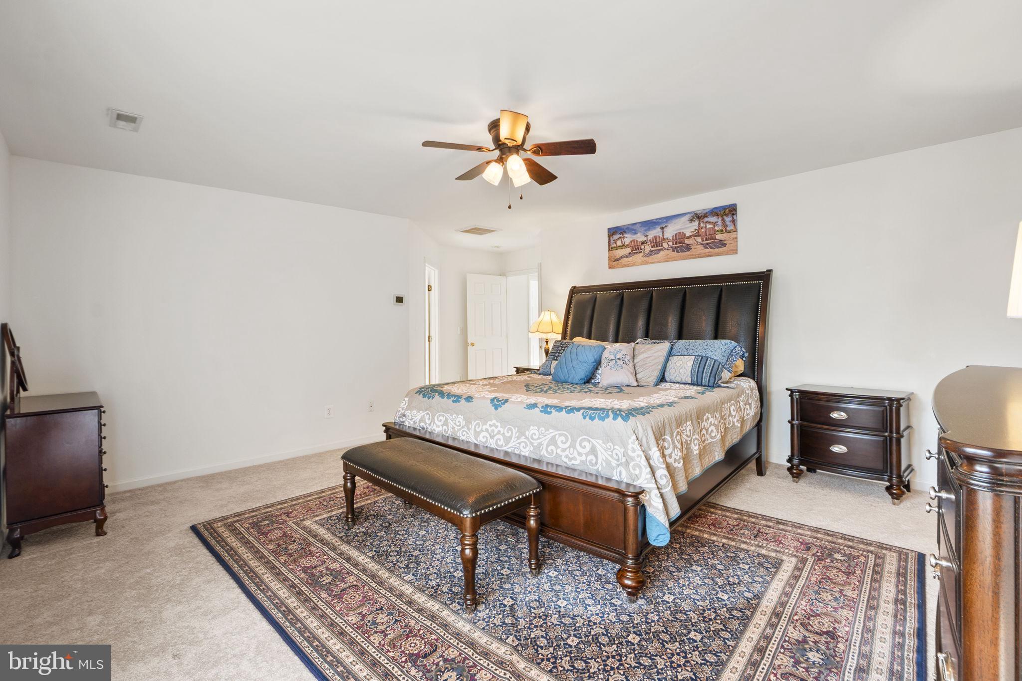 6528 Atkins Way Gainesville, VA 20155 - Photo 23 of 50 a bed sitting in a bedroom next to a lamp