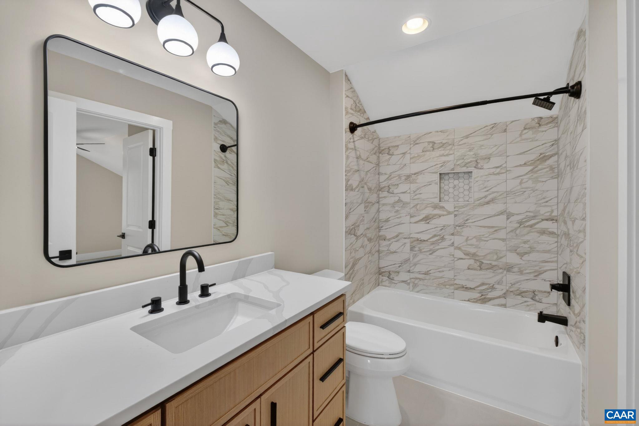 236 Palmer Place Ruckersville, VA 22968 - Photo 45 of 65 a bathroom with a sink a toilet a mirror a vanity and shower