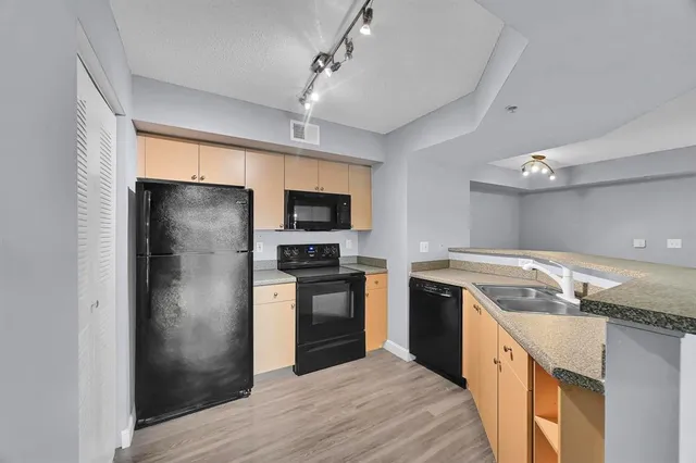 a kitchen with stainless steel appliances granite countertop a refrigerator a stove and a sink