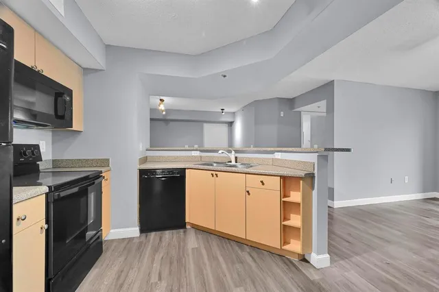 a kitchen with stainless steel appliances granite countertop a stove top oven a sink and a microwave