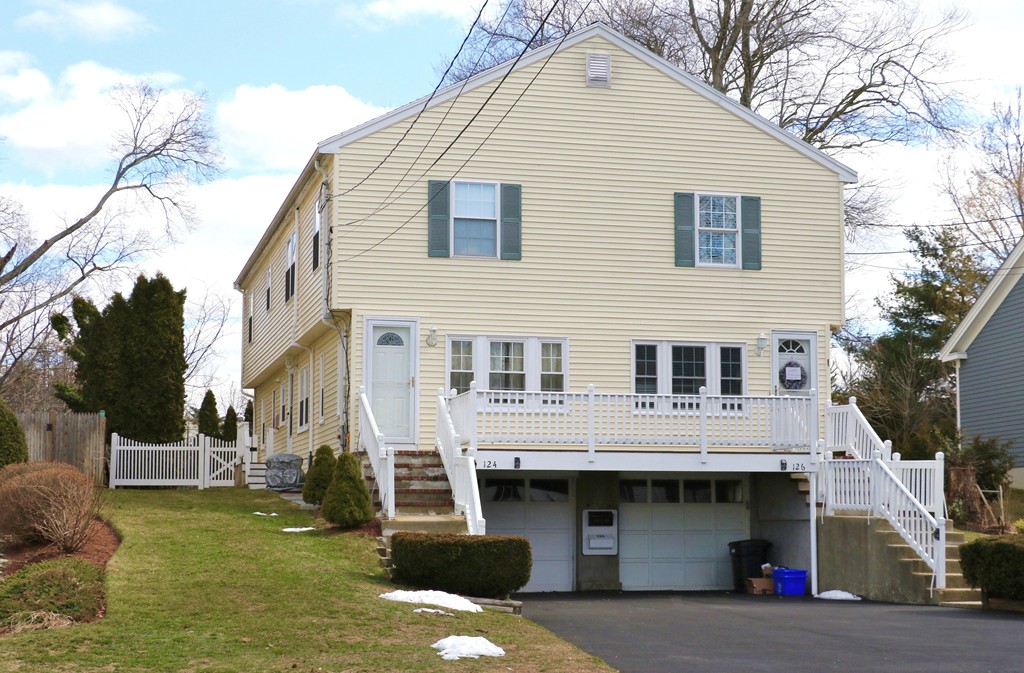 124 Maple Street, Unit 124 Needham, MA 02492 - Photo 1 of 16 a view of a white house with large windows and a small yard