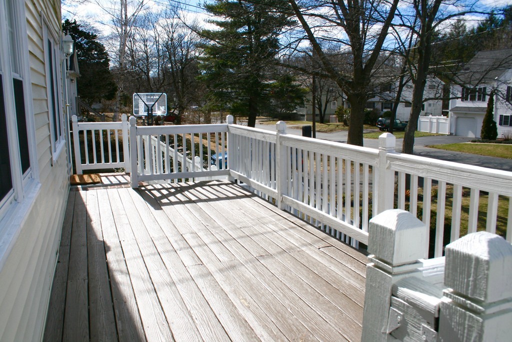 124 Maple Street, Unit 124 Needham, MA 02492 - Photo 2 of 16 a view of a deck with two chairs and a table with wooden floor