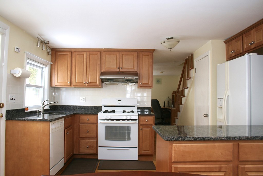 124 Maple Street, Unit 124 Needham, MA 02492 - Photo 7 of 16 a kitchen with granite countertop cabinets and white appliances