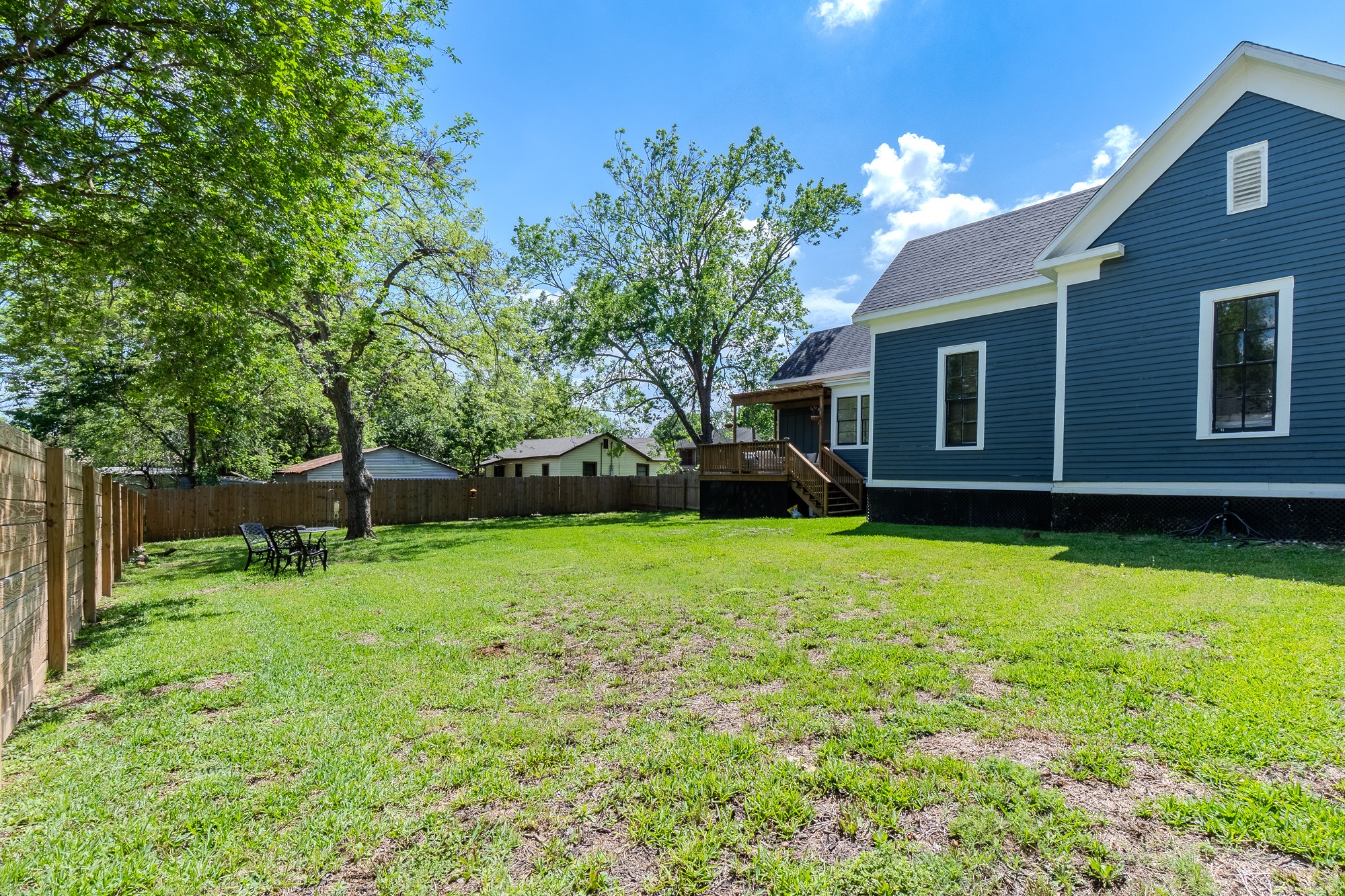 705 West 5th Street Brenham, TX 77833 - Photo 32 of 35 a view of a backyard with table and chairs a barbeque and a large tree