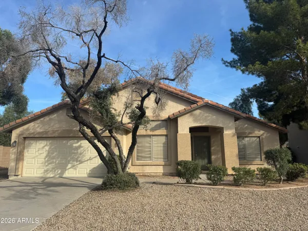 a view of a white house with a large tree