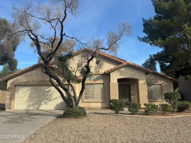 a view of a white house with a large tree