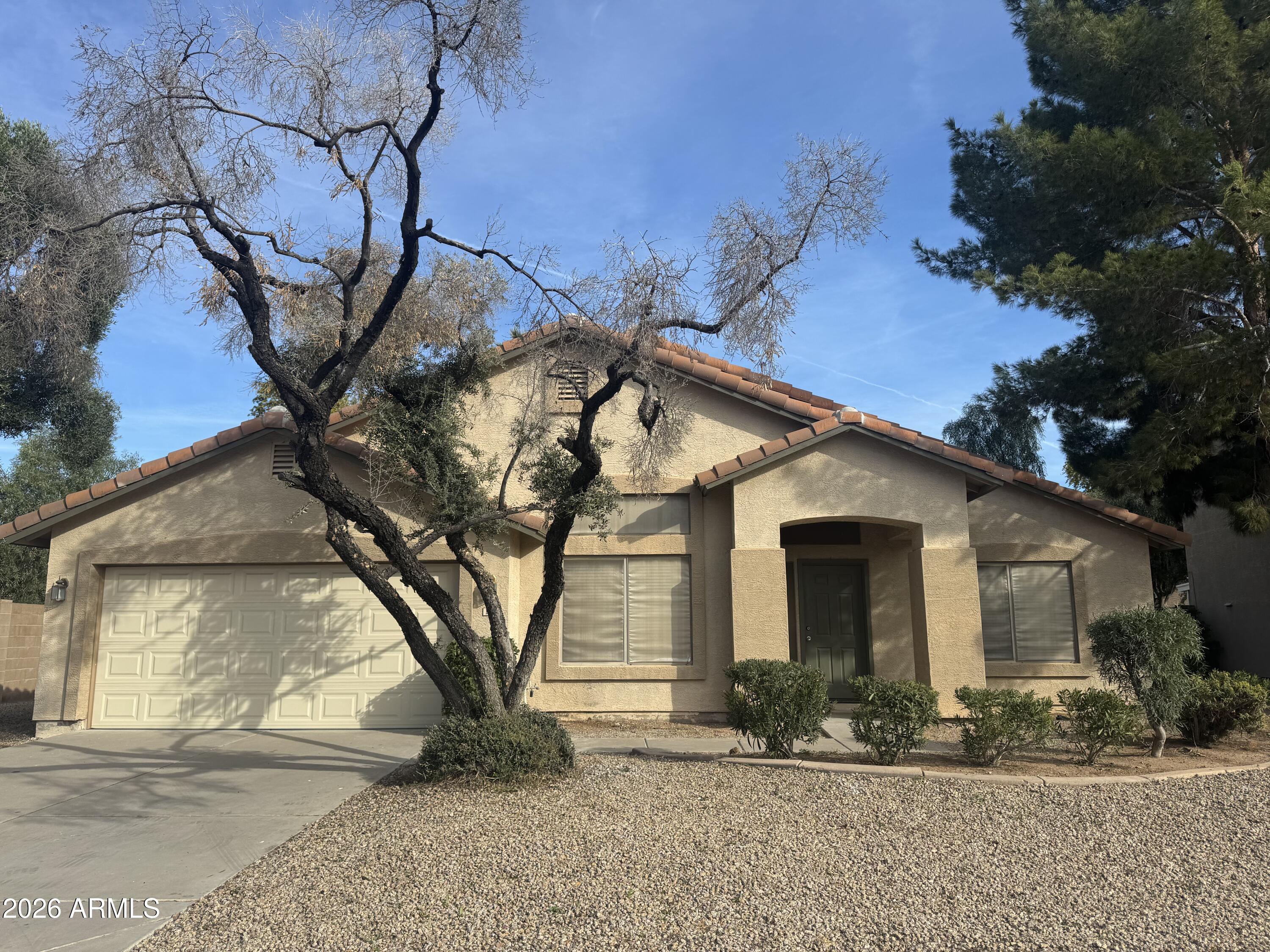 a view of a white house with a large tree
