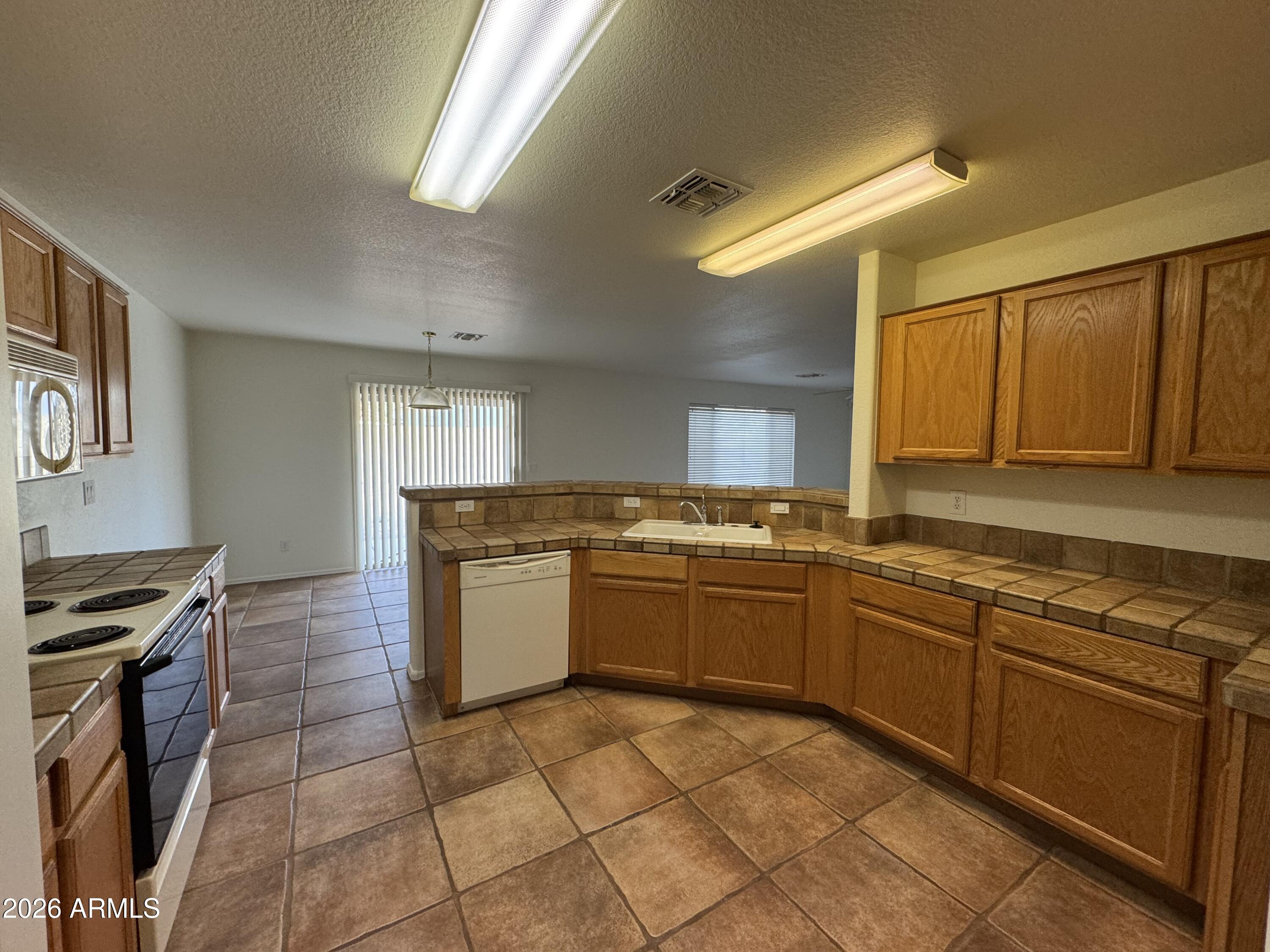 1126 East Shannon Street Gilbert, AZ 85295 - Photo 13 of 22 a kitchen with a stove a sink and a refrigerator