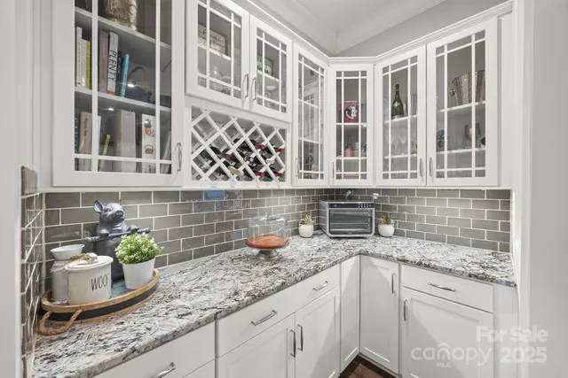 a kitchen with granite countertop a sink and a white cabinets