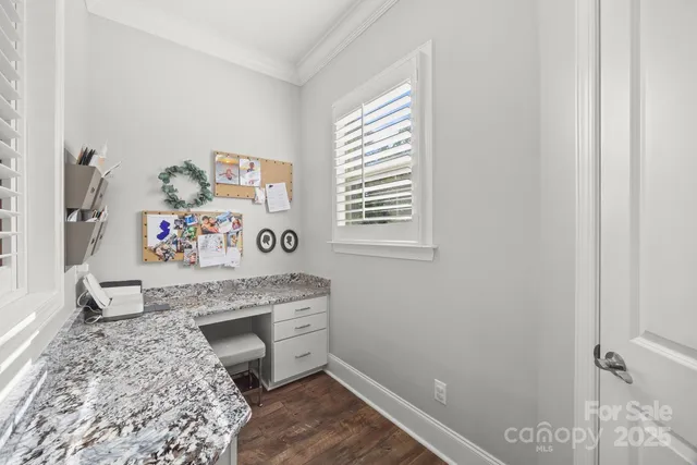 a view of a bedroom with baby bed and workspace