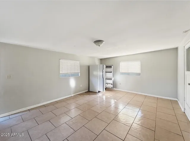 a view of an empty room with window and chandelier fan