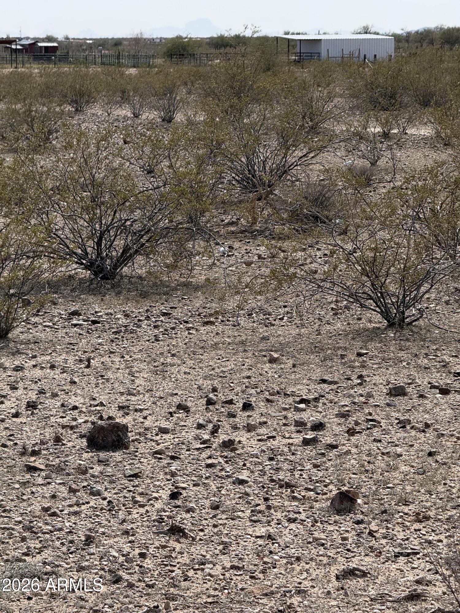 29999 West Peak View Road, Unit 15 Wittmann, AZ 85361 - Photo 13 of 20 a view of a dry field with trees in the background