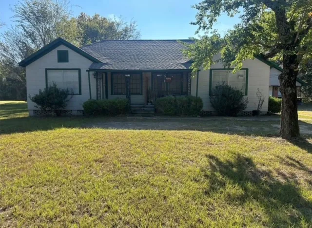 a front view of a house with a yard and trees