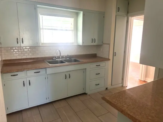 a kitchen with cabinets appliances and a window