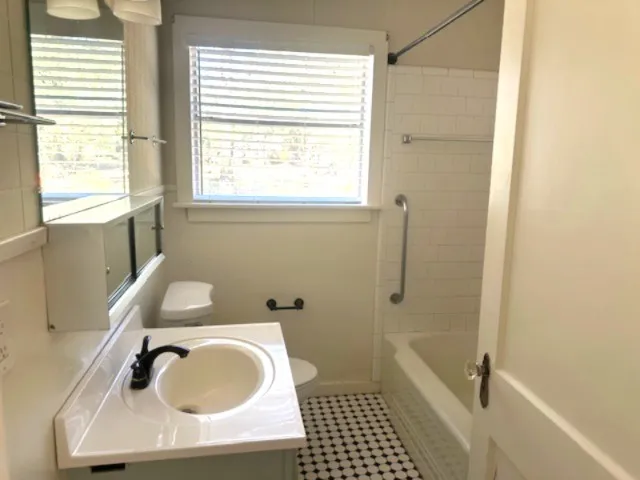 a bathroom with a sink a toilet and shower