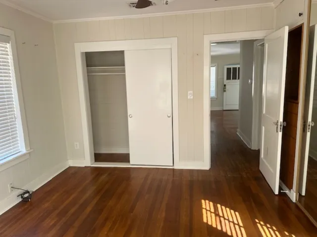 an empty room with wooden floor and entrance