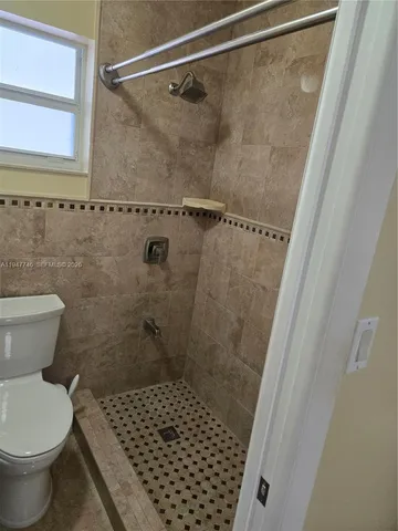 a bathroom with a toilet and a shower