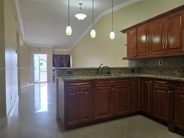 a kitchen with granite countertop stainless steel appliances wooden cabinets and a sink