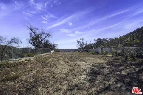 a view of a field with trees in the background