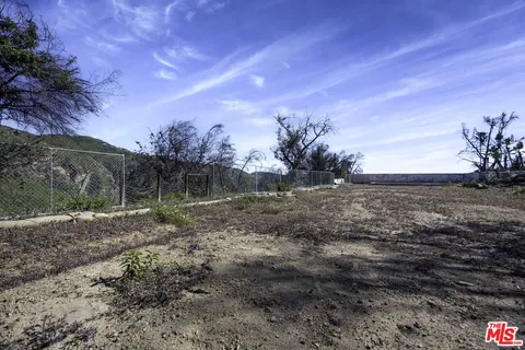 a view of a yard with wooden fence