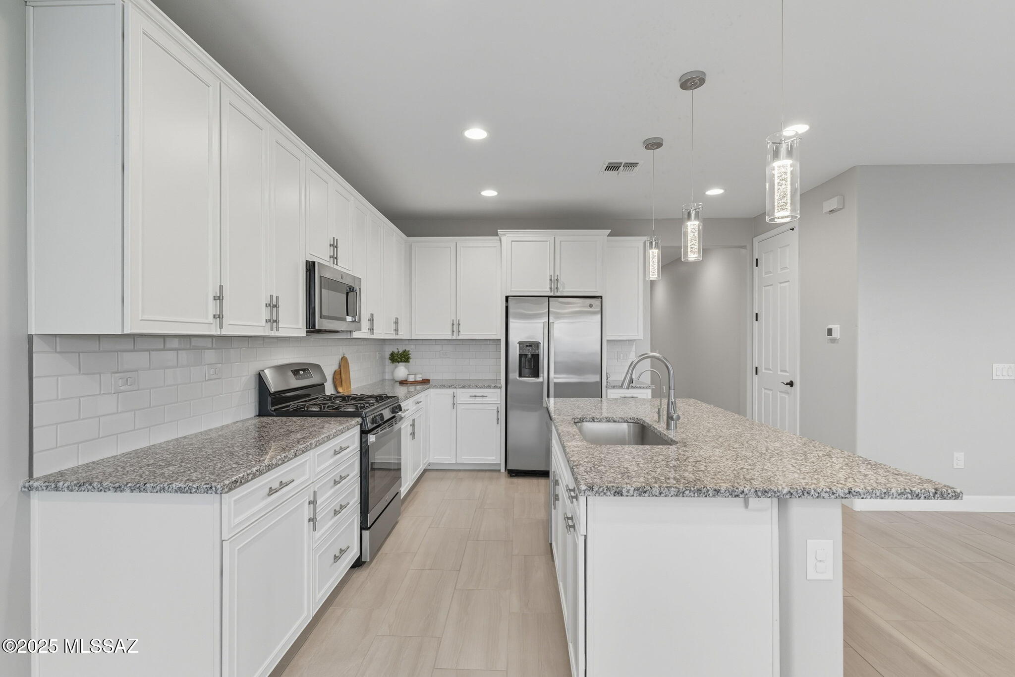12100 East Ryscott Circle Vail, AZ 85641 - Photo 11 of 53 a kitchen with stainless steel appliances granite countertop a sink stove and refrigerator