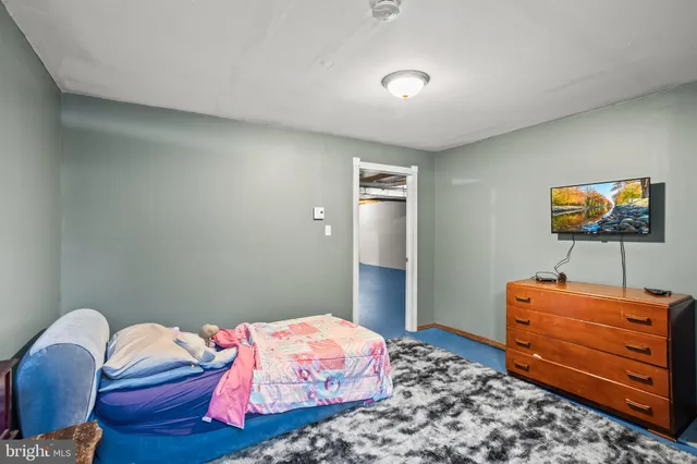 a bedroom with bed and flat screen tv