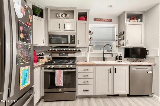 a kitchen with stainless steel appliances granite countertop a refrigerator sink and stove