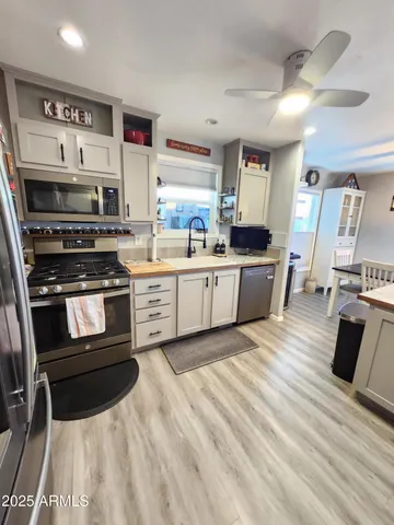 a kitchen with stainless steel appliances granite countertop a sink and a refrigerator