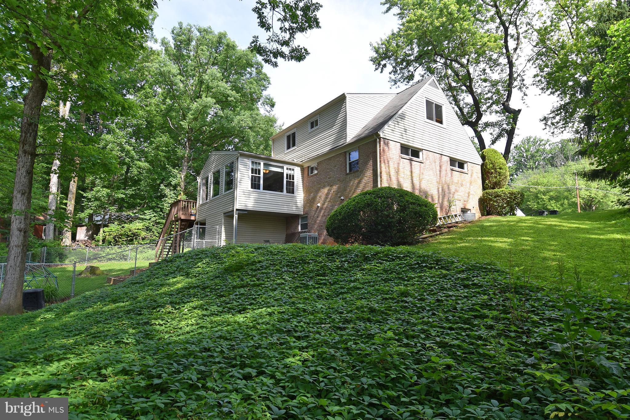 5506 Avon Court Springfield, VA 22151 - Photo 3 of 30 a view of a big house with a big yard plants and large trees