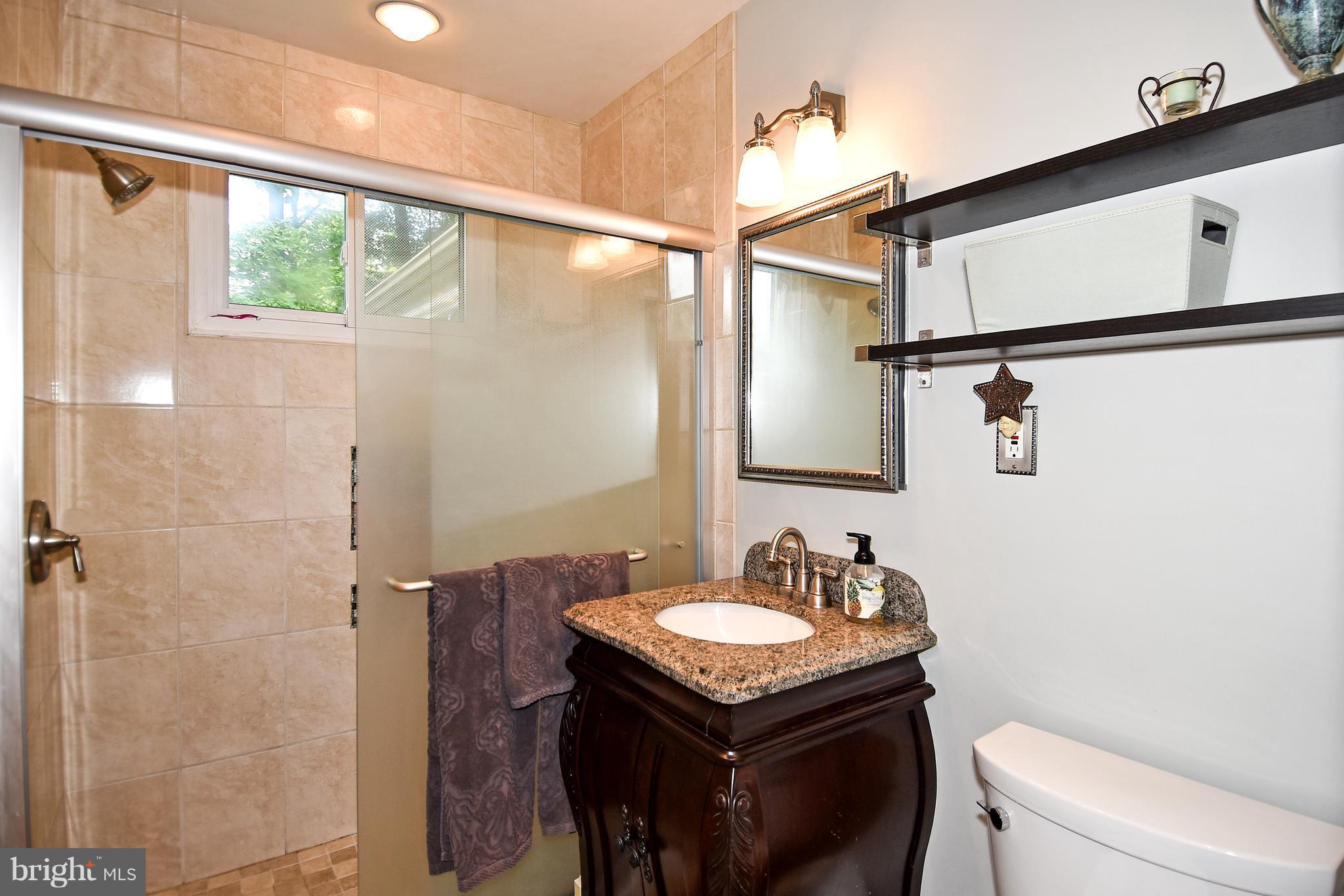 5506 Avon Court Springfield, VA 22151 - Photo 22 of 30 a bathroom with a granite countertop sink toilet and shower