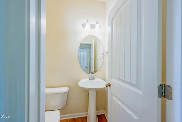 a bathroom with a toilet a sink and mirror