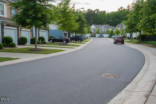 a view of road with houses and trees in the background