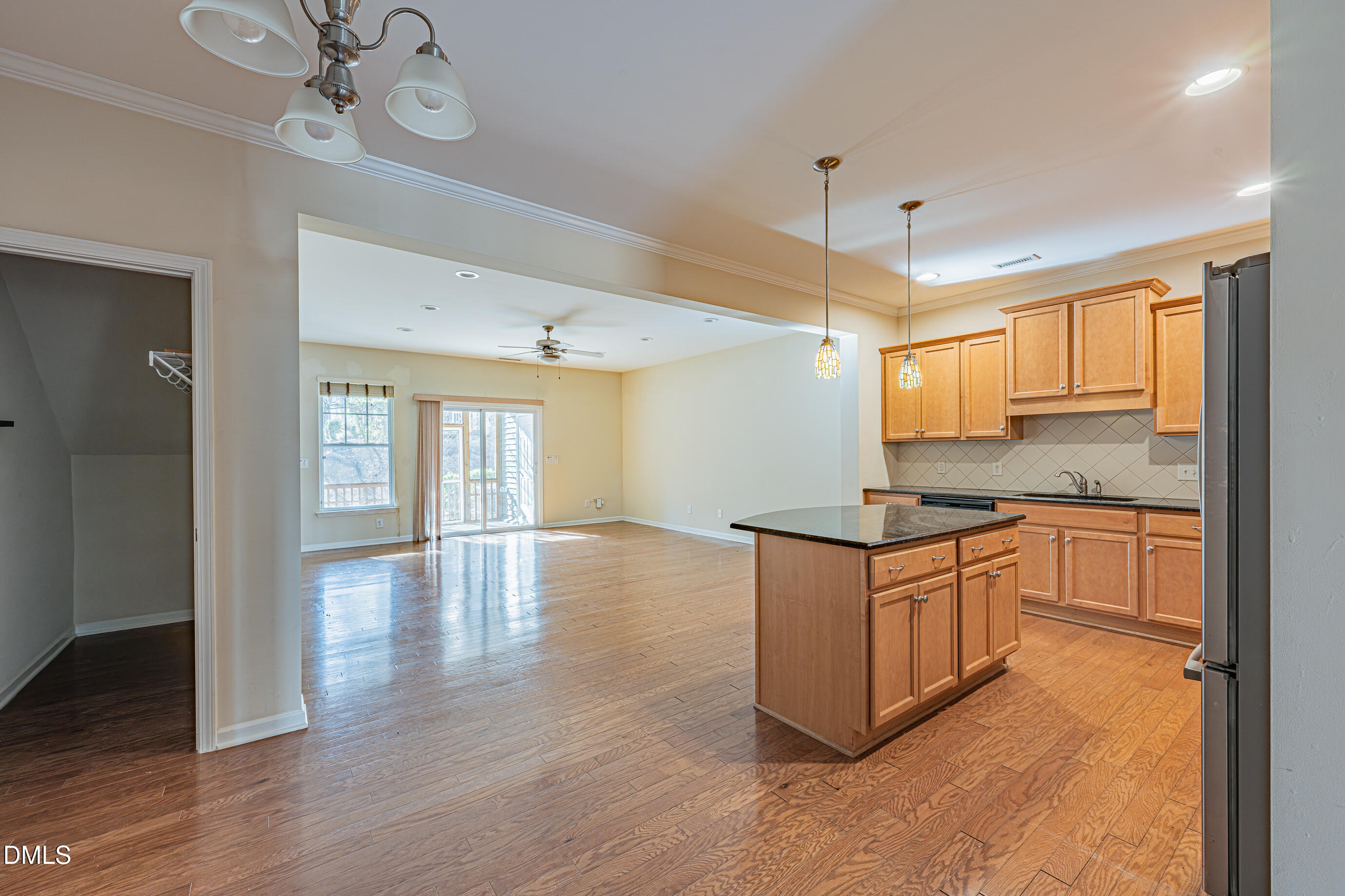 1260 Silver Beach Way Raleigh, NC 27606 - Photo 6 of 24 a kitchen with granite countertop a stove top oven a chimney cabinets and wooden floor