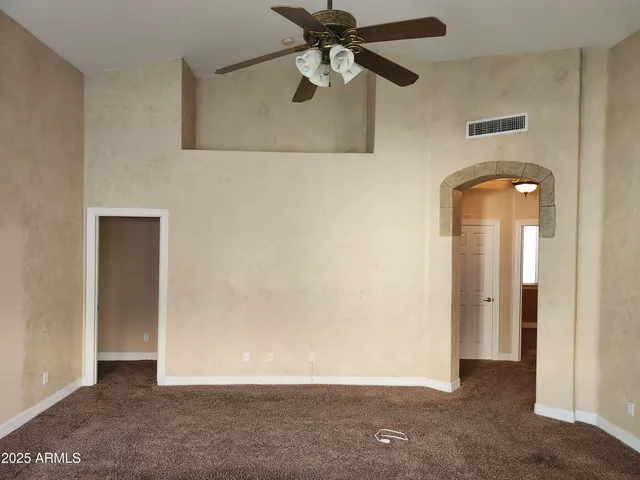 an empty room with windows and fan
