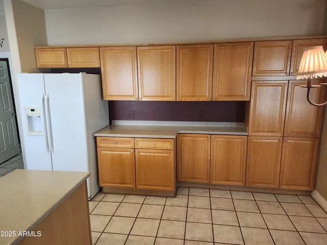 a kitchen with a refrigerator sink and cabinets
