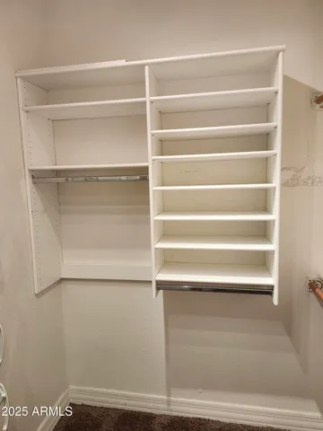 a view of walk in closet with empty racks