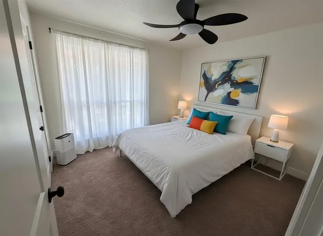 a bedroom with a bed dresser and a window